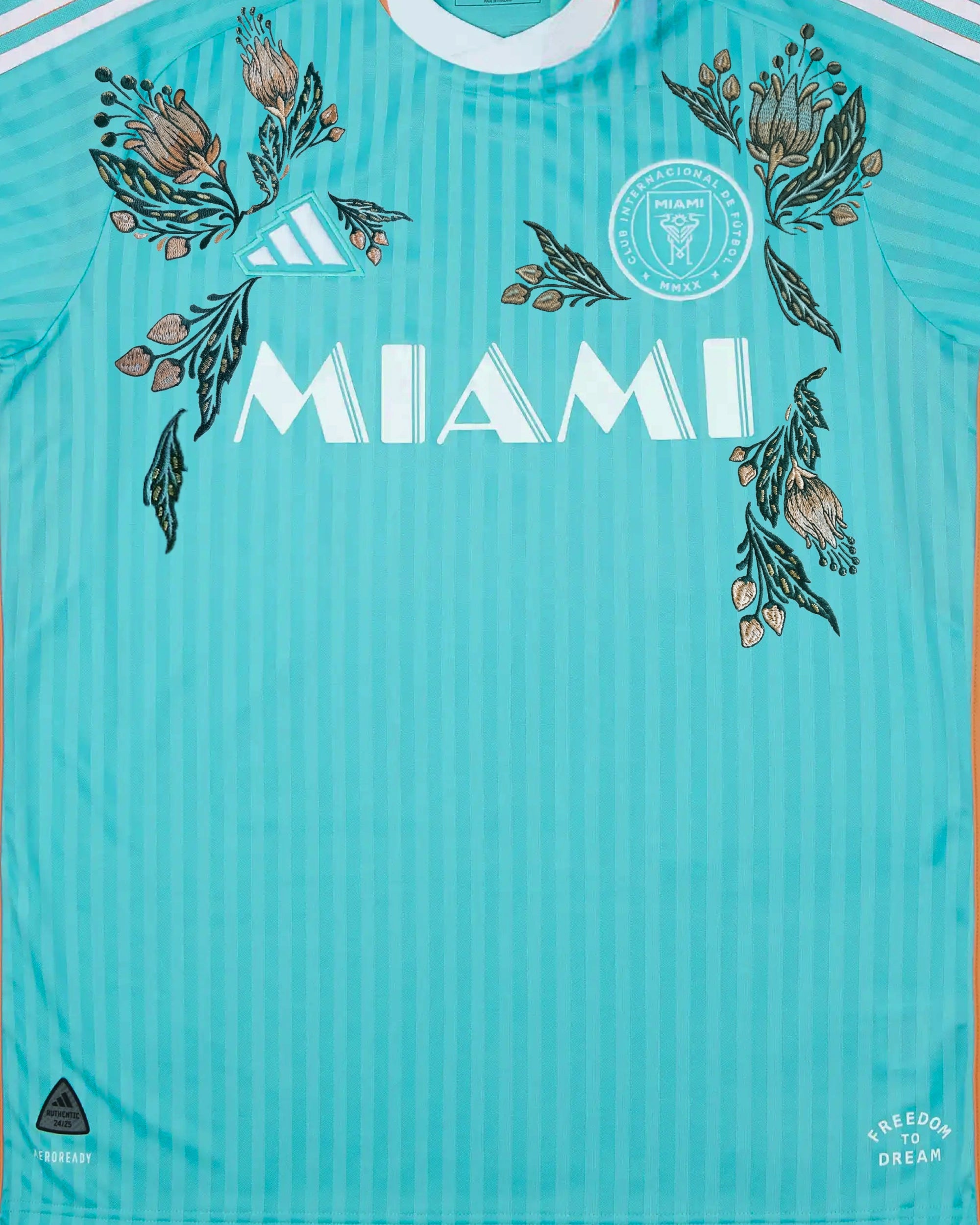 Macro Detail Of The Club Crest On The Inter Miami Embroidered Jersey Surrounded By Vibrant Tropical Stitching.
