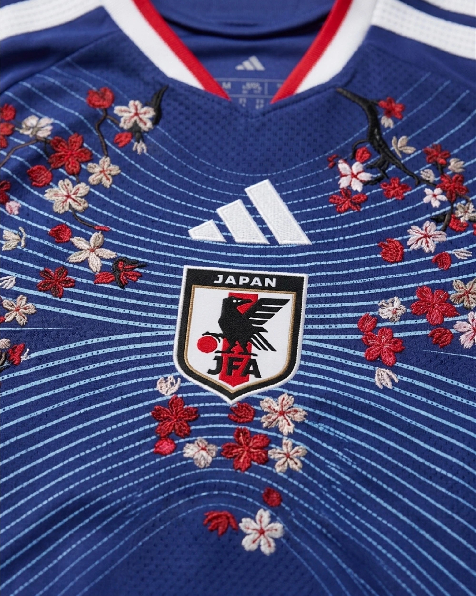 Close-Up Of The Japan Football Association Crest Framed By Bespoke Floral Hand-Stitched Motifs On The Japan Embroidered Jersey.